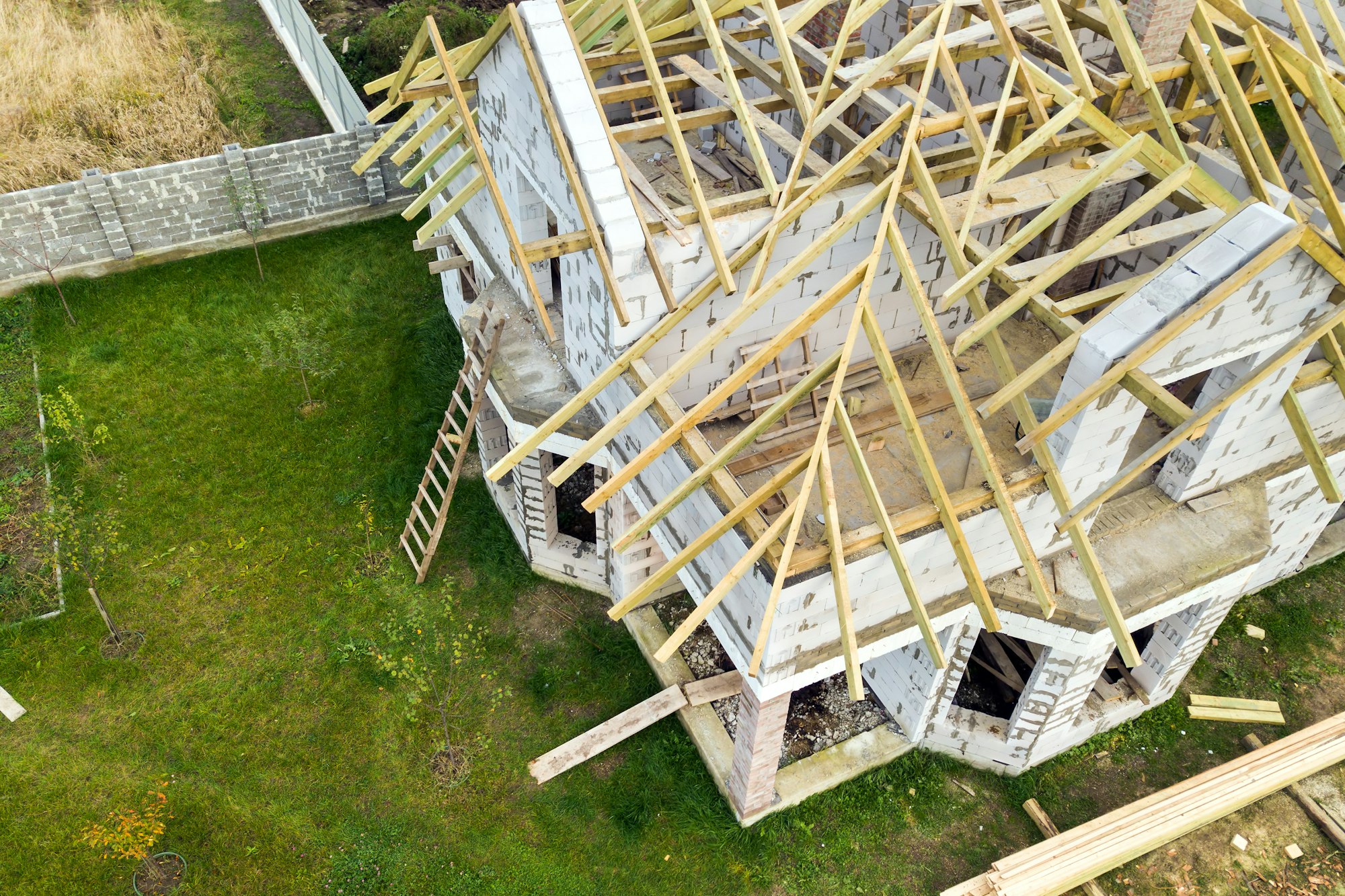 Aerial view of a private house with aerated concrete brick walls and wooden frame for future roof